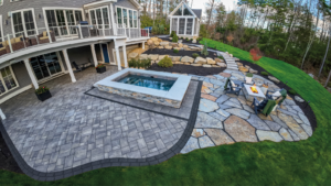 This image depicts a backyard retreat with a large patio, pool, firepit and walkway to create the perfect spot for outdoor entertaining.